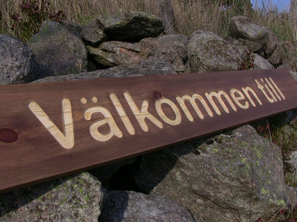 Träskylt välkommen